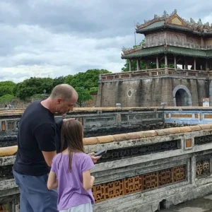 An adult and a child playing Urban Tales, an interactive exploration game, inside the Imperial Citadel of Hue, Vietnam.